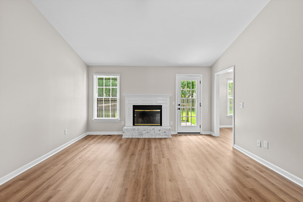 Large Family Room, Vaulted ceilings, New LVP flooring, Fireplace, white brick fireplace, blinds, Property listed by John Wesley Brooks