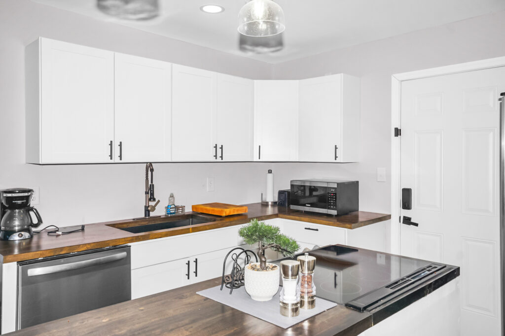 white kitchen cabinets, modern lighting, kitchen island, wood floors, listed by Huntsville best realtor, John Wesley Brooks