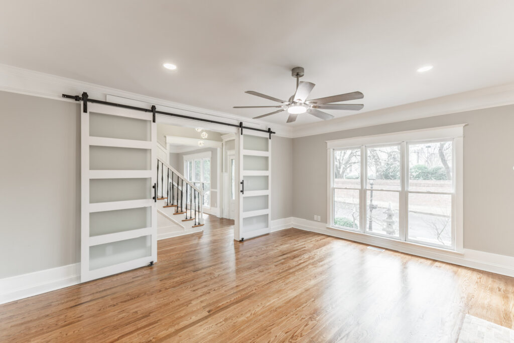 Family Room, grey walls, wood floors, recess can lights, modern doors, open windows and fireplace, modern light fixtures, luxury blossomwood home, listed by top realtor John Wesley Brooks in Huntsville alabama 