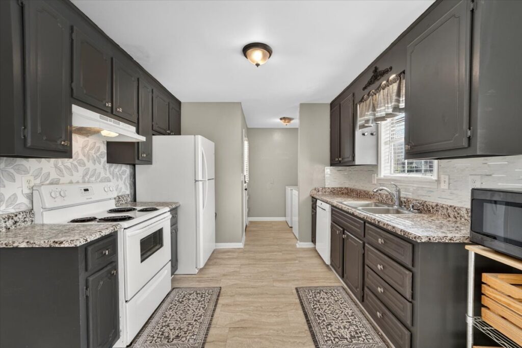 renovated kitchen, brown grey cabinets, wood floors, painted grey walls. Home listed by Top Realtor John Wesley Brooks