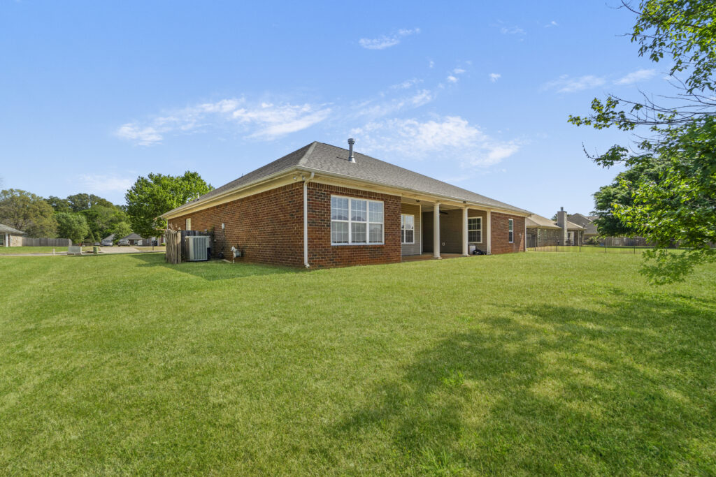 Backyard, green grass, blue skies, full brick home for sale in Meridianville Alabama 