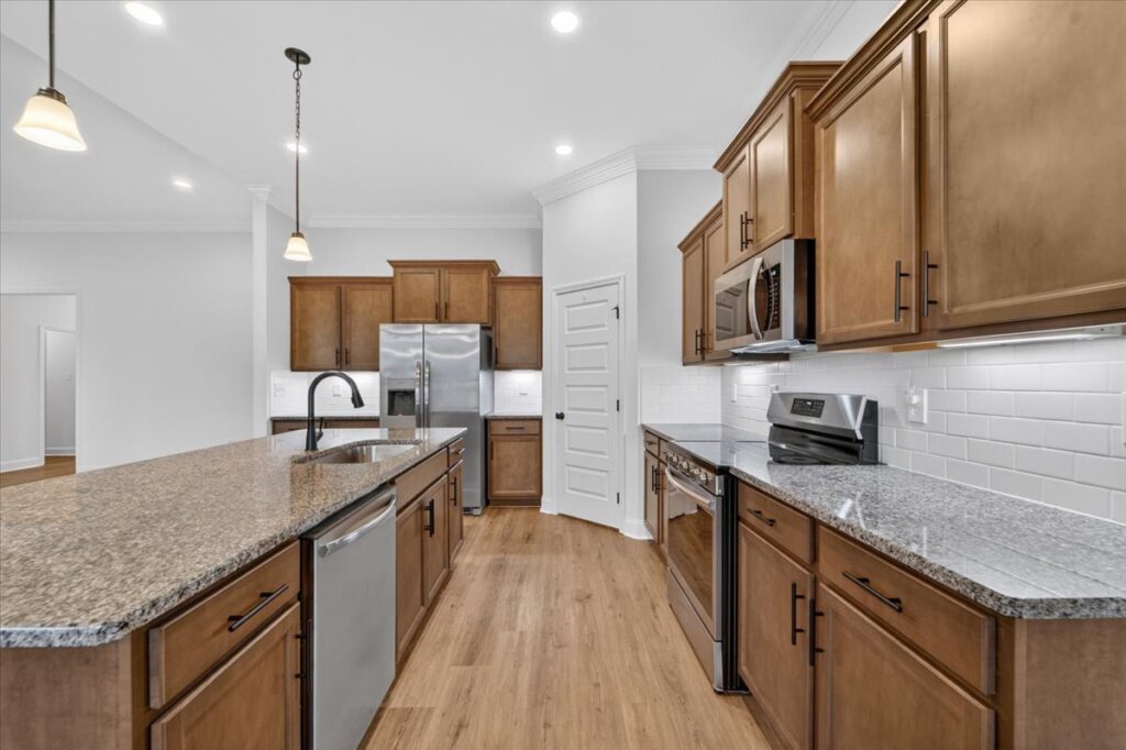 Kitchen view, modern kitchen, upgraded home, brown cabinets, granite counter tops, property listed by top realtor John Wesley Brooks