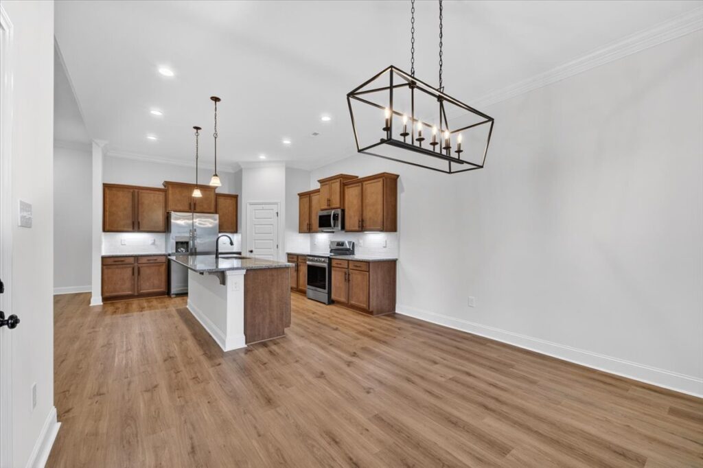 Dining room and kitchen view, LVP floors, modern open floor plan, light wall color, modern light fixtures, recess can lights, kitchen island, modern layout, Home for sale in Harvest by Top Huntsville Alabama Realtor John Wesley Brooks