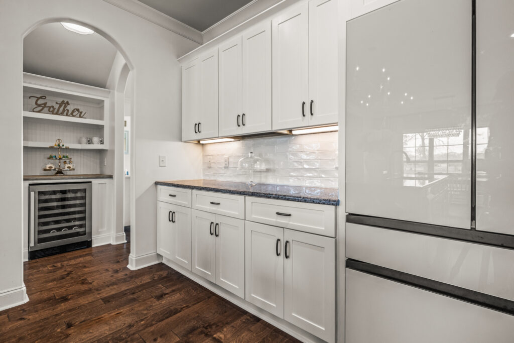 White cabinets, wood floors, modern kitchen design, under cabinet light, white refrigerator, bar, crown molding, custom design, HGTV inspired home, listed by Huntsville best Realtor John Wesley Brooks, Home for sale in Meridianville Alabama 