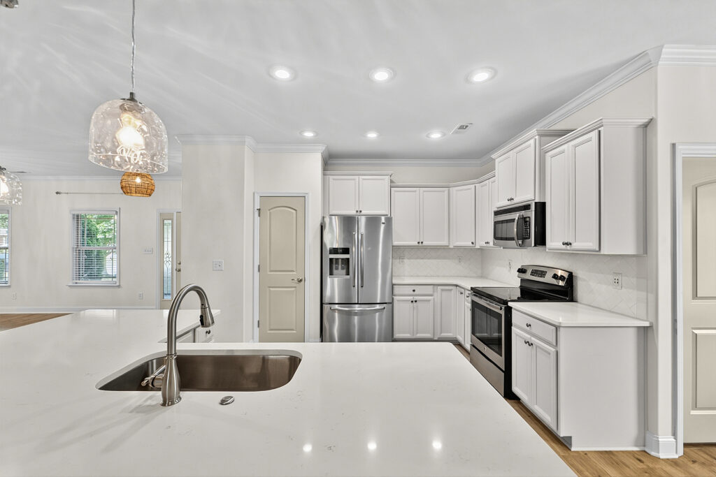 View of the interior of the kitchen, white cabinets, upgraded counters, white granite counters, upgraded light fixtures, stainless steel appliances, listed by Huntsville best realtor, John Wesley Brooks